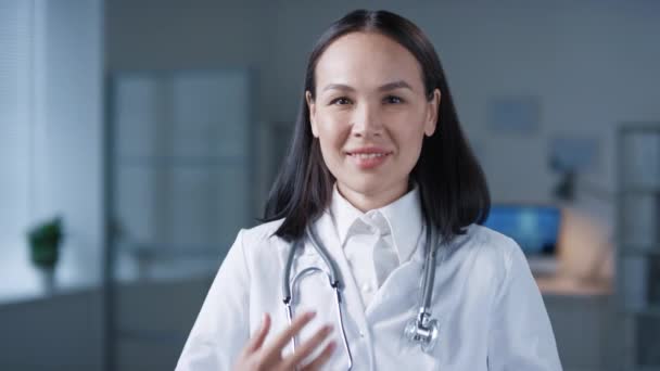 Beyaz Önlüklü Kameraya Gülümseyen Çekici Asyalı Kadın Doktorun Göğüs Portresi — Stok video