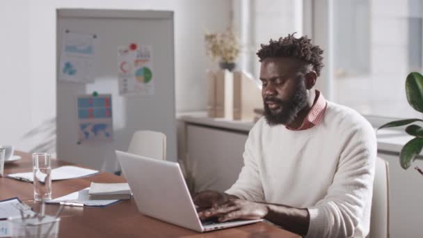 Średni Portret Afroamerykanina Siedzącego Przy Stole Pokoju Biurowym Pracującego Laptopie — Wideo stockowe