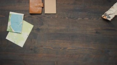 Ahşap yüzeyde çeşitli seyahat aksesuarları düzenleyen tanınmayan bir kadının zaman aşımlı üst görüntüsü.