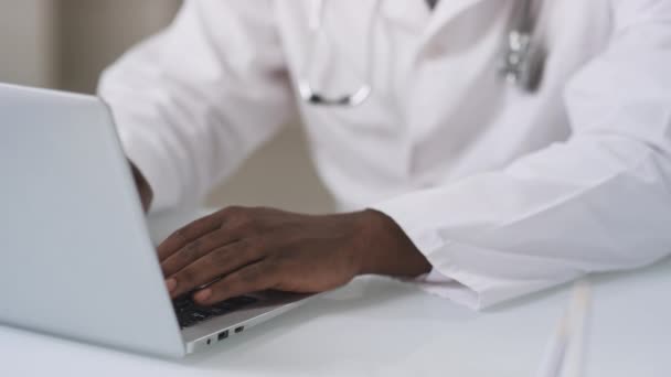 아프리카계 미국인 코트를 병원에 사무실 방에서 노트북으로 뭔가를 타이핑하고 — 비디오