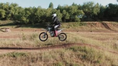 Ormandaki off-road pistinde motosikletle yarışan üç sporcunun robot resmi.