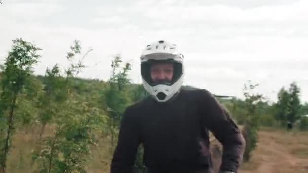Tracking Shot Mężczyzn Kaskach Biegów Jazdy Motocykli Wzdłuż Brudnej Drogi — Wideo stockowe