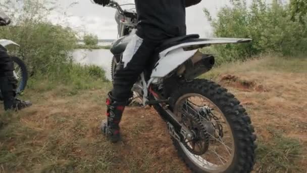 Rastreamento Homens Capacetes Iniciando Motocicletas Cavalgando Depois Descansar Junto Lago — Vídeo de Stock