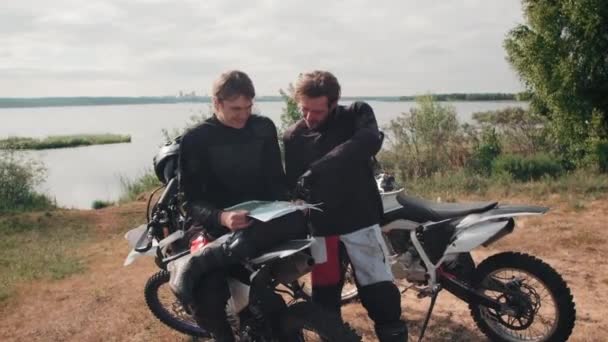 Rastreamento Lento Motociclistas Alegres Descansando Junto Lago Dia Nublado Planejando — Vídeo de Stock