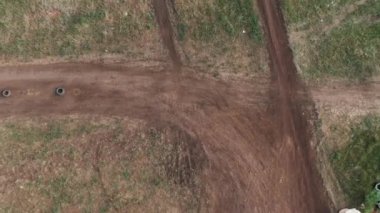 Kask takmış, motosiklet süren ve toprak yolda yarışan tanınmamış insanların hava görüntüsü.
