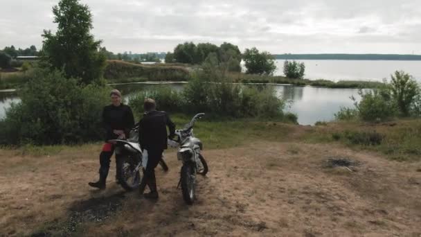 Drone Seguimiento Disparo Hombres Alegres Descansando Sus Motocicletas Por Lago — Vídeo de stock