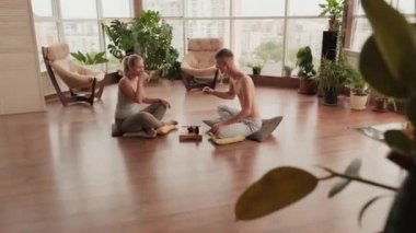 Yoga yaptıktan sonra küçük bardaklardan Hint çayı içen mutlu, genç, beyaz bir çift.