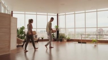 Bir çift genç Kafkas yogası sadhu-yoga antrenmanına hazırlanıyor. Yer çekimi tahtasını yere koyuyorlar.