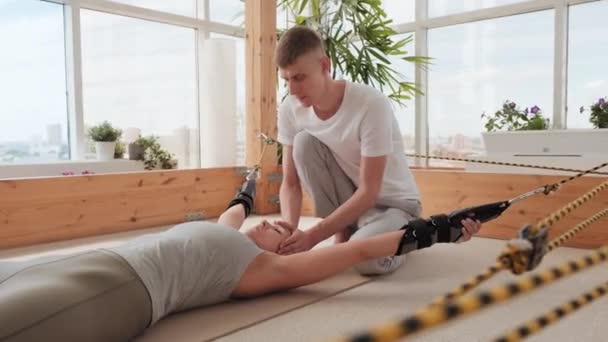 Tiro Médio Instrutor Masculino Ajudando Jovem Mulher Resistente Treinar Estimulador — Vídeo de Stock