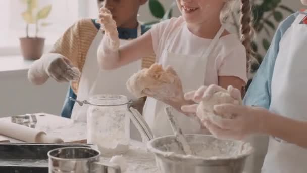 앞치마를 다수의 소녀들이 밀가루로 뒤덮인 과자를 준비하고 늘어뜨리고 손으로 반죽을 — 비디오