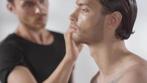 Fotografía Media Del Maquillador Masculino Enfocado Que Aplica Fundación Cara — Vídeos de Stock