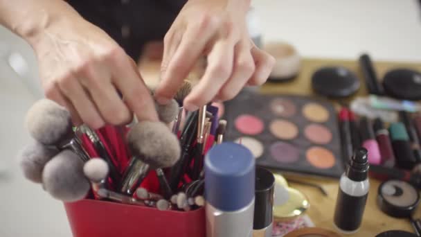Zbliżenie Nierozpoznawalnego Makijażysty Wybierającego Pędzel Produkty Kosmetyczne Leżące Stole — Wideo stockowe