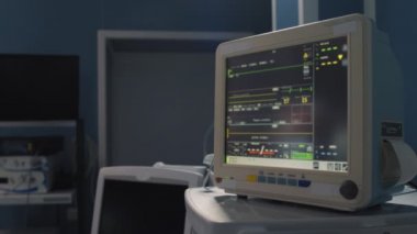 Close up of surgical display with patient health indicators and surgeon getting ready for operation in modern hospital