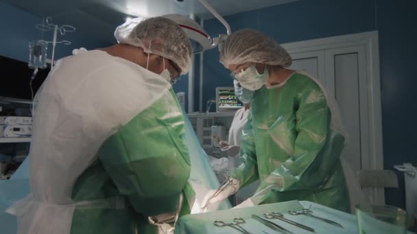 Średnie Ujęcie Zespołu Chirurgów Specjalnej Sterylnej Odzieży Maskach Operujących Pacjenta — Wideo stockowe