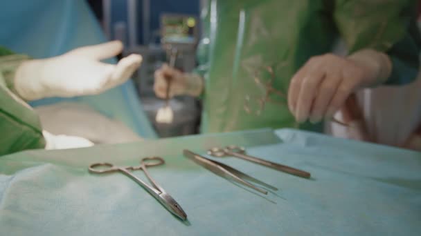 Zbliżenie Nierozpoznawalnych Dłoni Asystenta Medycznego Podającego Nożyczki Chirurgiczne Profesjonalnemu Chirurgowi — Wideo stockowe