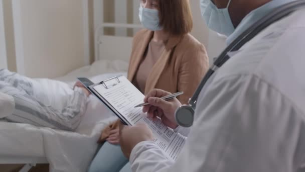民間病院の明るい部屋に座っている患者と相対的な診断を伝える資格の医師の中程度の閉鎖 — ストック動画