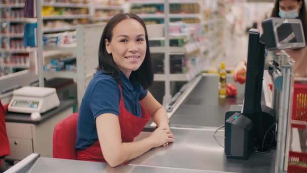 Средний Портрет Дружелюбной Женщины Форме Работающей Кассиром Большом Супермаркете Улыбающейся — стоковое видео