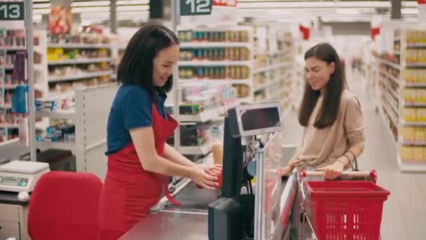 Medium Shot Smiling Female Cashier Red Uniform Talking Joyful Woman — Stockvideo
