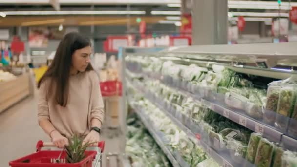 Medium Shot Young Caucasian Woman Product Cart Choosing Greens Counter — Stockvideo