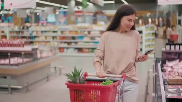 Medium Footage Nice Smiling Woman Cart Choosing Products Hypermarket Walking — Stockvideo