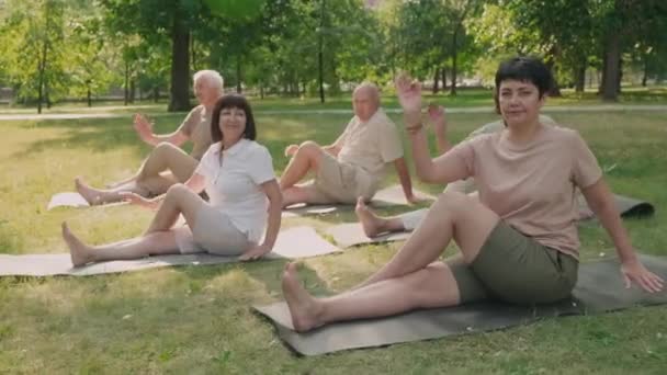 Wide Shot Five People Sitting Mats Lawn Park Practicing Yoga — Stockvideo