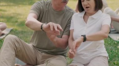 Neşeli, yaşlı, beyaz bir adam ve parkta birlikte oturan melez bir kadın. Yoga kursunda akıllılıklarını karşılaştırıyorlar ve sonra da kameraya bakıyorlar.