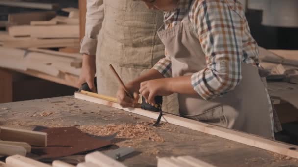Nagranie Sekcji Środkowej Nierozpoznawalnego Chłopca Mierzącego Kawałek Drewna Tapetą Dorosłego — Wideo stockowe