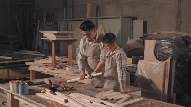 Střední Záběr Veselého Otce Syna Pracující Truhlářství Broušení Kus Dřeva — Stock video