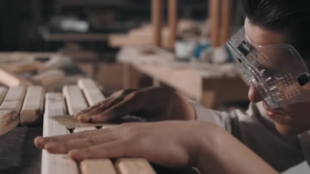 Close up of professional craftsman in protective glasses sanding wooden surface of diy furniture with sandpaper in carpentry workshop — Stock Footage Close Professional Craftsman Protective Glasses Sanding Wooden Surface Diy Furniture Royalty Free Stock Video