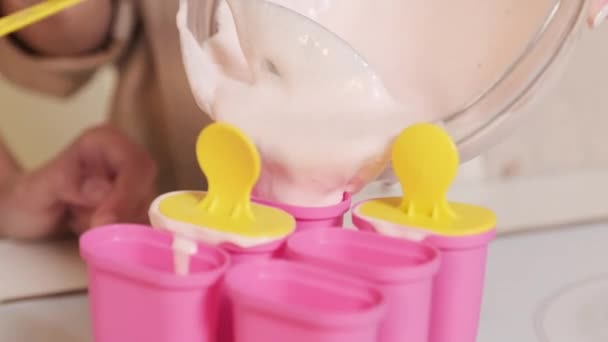 一只无法辨认的雌性手拿着装有甜液体冰淇淋的玻璃碗 用棍子倒在塑料模子里 然后冷冻 — 图库视频影像