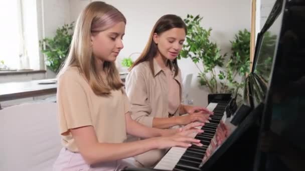 Média Tiro Mulher Caucasiana Atraente Ensinando Filha Adolescente Tocando Piano — Vídeo de Stock