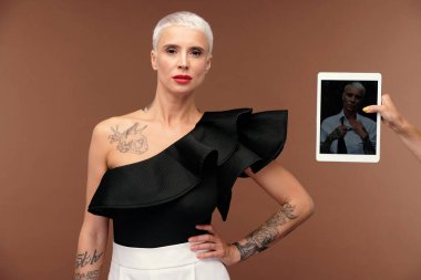 Ekranında zarif bir kadının olduğu, göğsünde siyah bir tişört olan sarışın transseksüel bir kadının ellerinin değdiği bir defter.