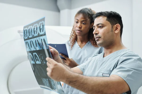 Ernstige Gemengde Ras Radioloog Zijn Afrikaanse Vrouwelijke Assistent Uniform Analyseren — Stockfoto