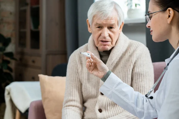 Jonge Vrouwelijke Arts Whitecoat Kijkt Naar Thermometer Het Meten Van — Stockfoto