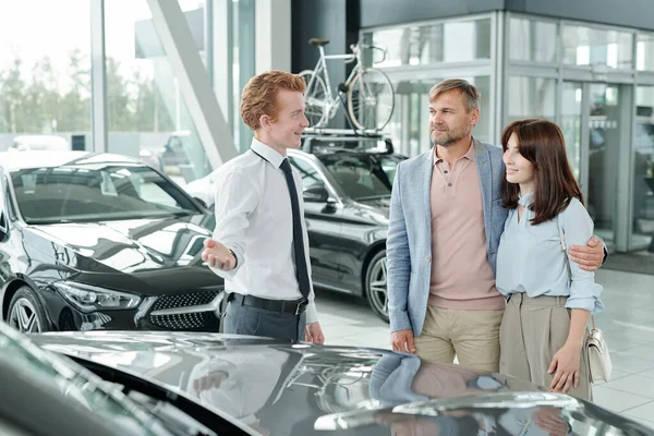 Confident Young Sales Manager Modern Auto Center Showing One New — Stock Photo, Image