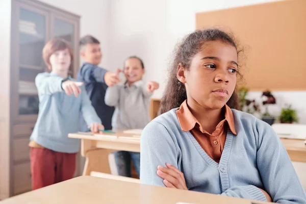 Offended Mixed Race Schoolgirl Sitting Desk Crossing Arms Chest Background — Stock Photo, Image