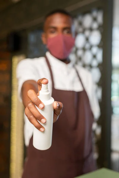 Ręka Współczesnego Kelnera Pochodzenia Afrykańskiego Będzie Spryskiwać Santitizerem Oferując Klientom — Zdjęcie stockowe