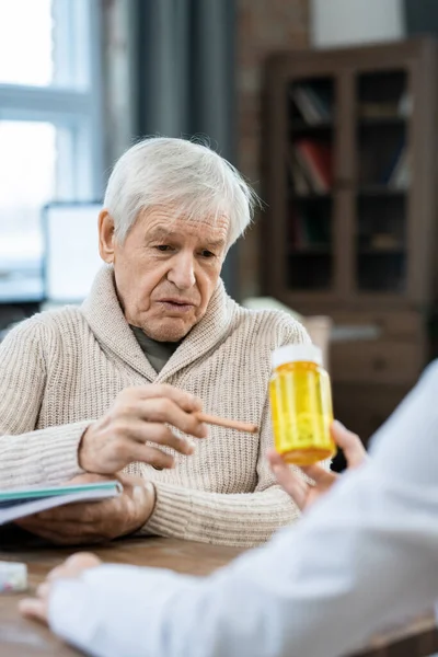 Senior Man Casualwear Looking Pointing Bottle Pills Hands Female Doctor — Foto Stock