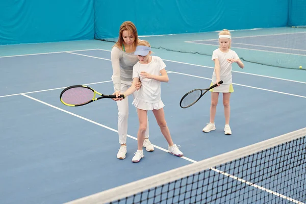 Junge Tennistrainerin Aktivkleidung Hält Schläger Der Hand Eines Von Zwei — Stockfoto