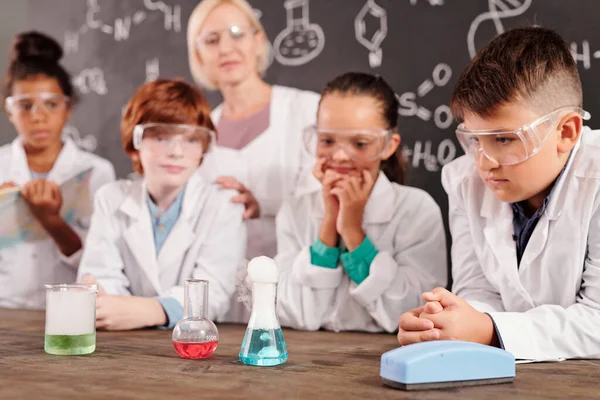 Serious Clever Schoolkids Whitecoats Protective Eyeglasses Watching Different Reactions Glass — Stock Photo, Image