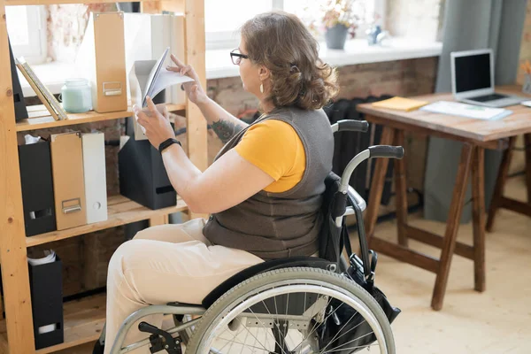 Jonge Invalide Vrouwelijke Kantoormedewerker Casualwear Kijkend Door Papieren Een Van — Stockfoto