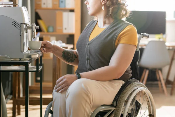 Tekerlekli Sandalyedeki Genç Kadını Kahve Makinesinin Önünde Oturuyor Günün Ortasında — Stok fotoğraf