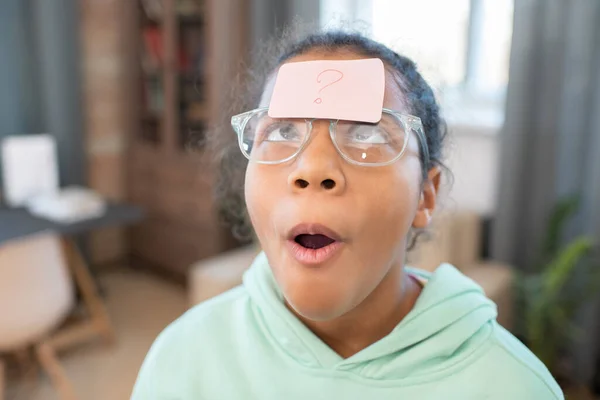 Niedliches Mischlingsmädchen Freizeitkleidung Und Brille Blickt Auf Zettel Mit Fragezeichen — Stockfoto