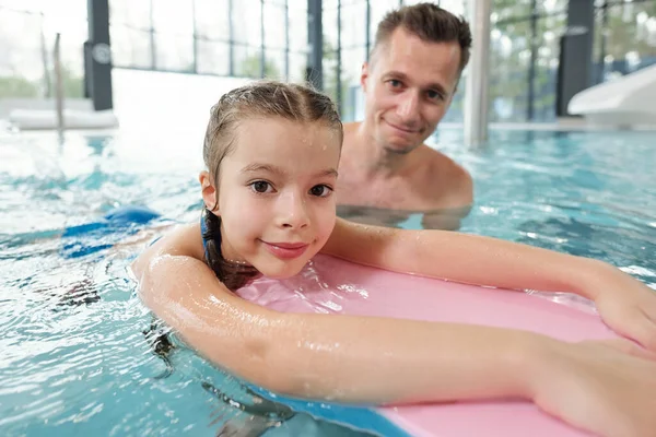 Niña Mojada Con Tabla Natación Mirándote Desde Agua Mientras Aprende —  Fotos de Stock