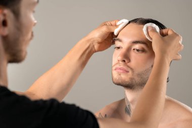 Makyaj sanatçısının makyaj stüdyosunda makyajdan önce yüzünü temizlemek için pamuk kullanması.