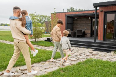 Mutlu, genç, çağdaş bir aile ve iki küçük çocuk yeni evlerine doğru ilerliyorlar.