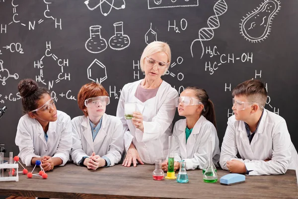 Junge Blonde Chemielehrerin Weißen Kittel Zeigt Gruppe Süßer Schüler Mischung — Stockfoto