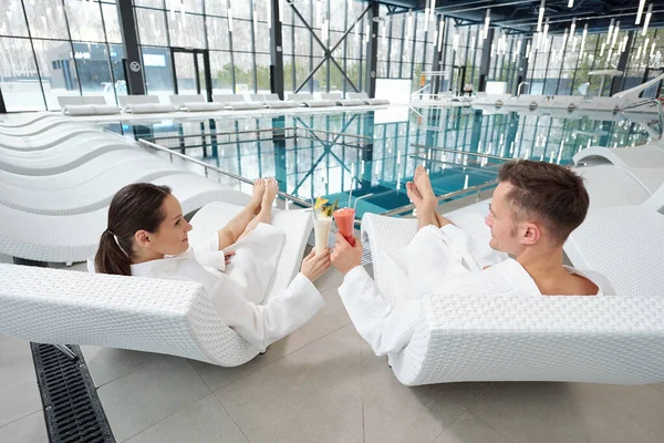Rear View Young Restful Couple White Bathrobes Sitting Deckchairs Poolside — Stock Photo, Image