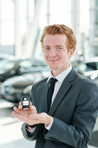 Otomobil Merkezindeki Genç Neşeli Erkek Satıcı Yeni Araçların Karşısında Dururken — Stok fotoğraf