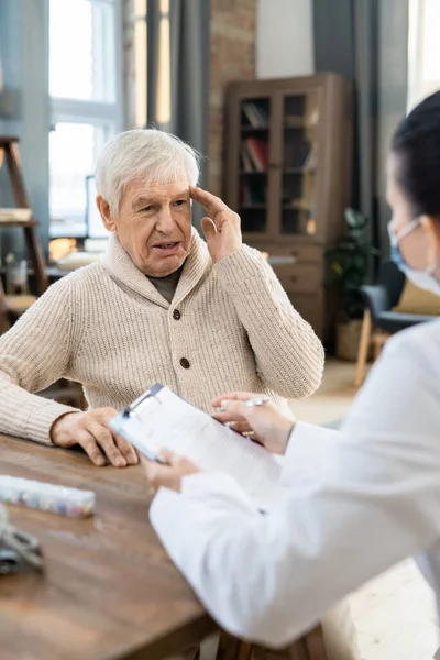 Sick Senior Man Casualwear Looking Young Female Doctor Whitecoat Medical — Fotografia de Stock